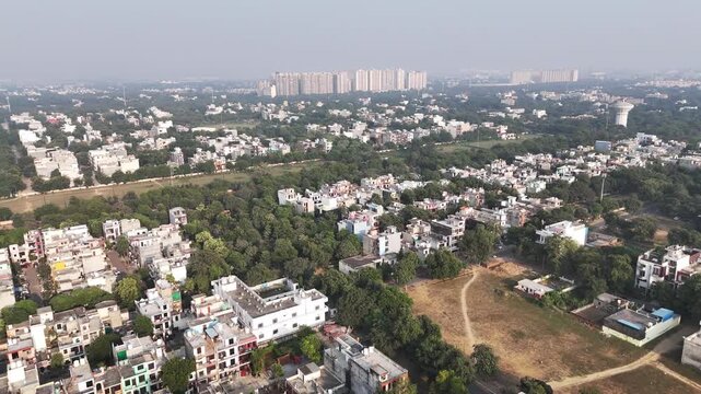 Aerial view of residential buildings and lush green trees in the urban landscape of Greater Noida, Uttar Pradesh, India.