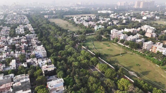 Aerial view of residential neighborhood with tree-lined streets and green parks in Greater Noida, Uttar Pradesh, India.