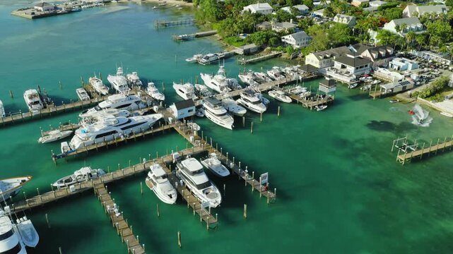 Aerial view of yachts and boats docked at a marina in clear turquoise water in Dunmore Town, Harbour Island, The Bahamas.