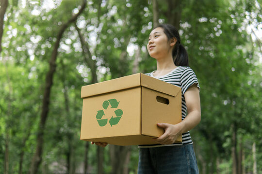 Sustainable environment concept. Recycle plastic free of zero waste, from waste to environment, woman holding recycling box on green nature forest background.