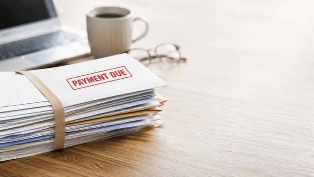 Payment Due Envelope on Stack of Bills and Documents on Office Desk with Copy Space