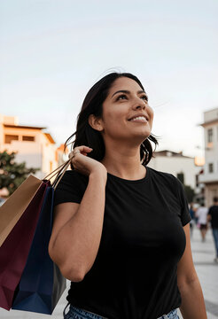 Smiling young woman carrying shopping bags on her shoulder, looking up with a happy expression outdoors, Moment of contentment and joy in an urban setting