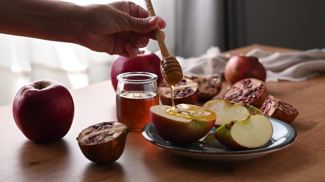 Pouring honey over apple slices for Rosh Hashanah celebration