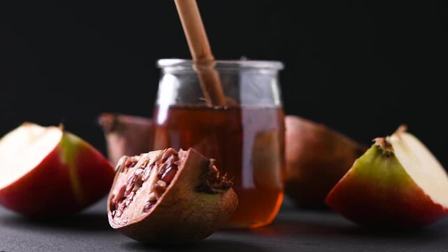 Rotating honey jar, pomegranates and apples for Rosh Hashanah celebration