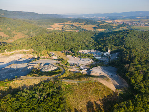 Aerial view of the Eurovia stone quarry near Viglas, with industrial facilities, gravel piles, and dense forests in Detva, Banskobystricky kraj, Slovakia.