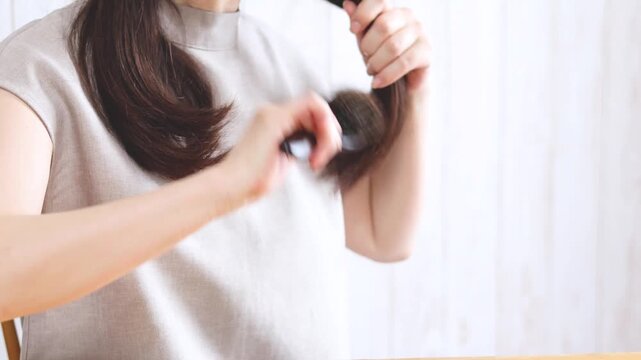 セミロングの髪をブラッシングする女性