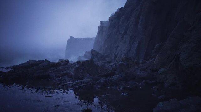 stormy rocky shoreline under blue dusk, crashing waves and spray, jagged cliff faces receding into fog, high contrast mood, raw energy and cinematic tension