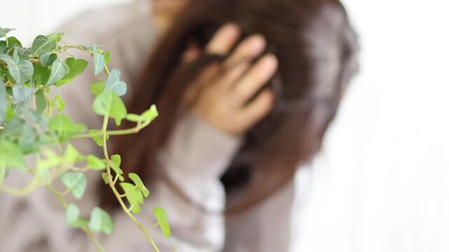 頭を抱えて悩む女性　ひとりで苦しむ様子
