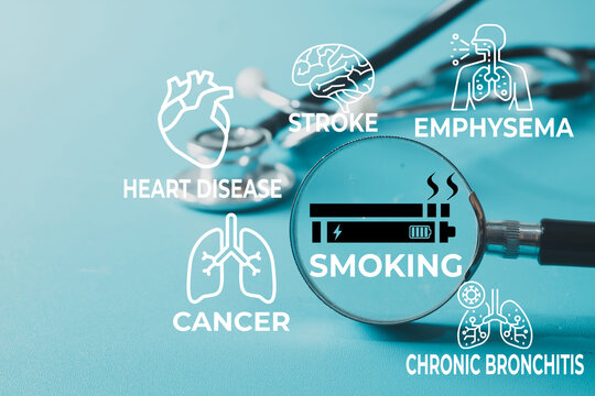 Smoking health risks concept. Magnifying glass focusing on smoking icon surrounded by heart disease, stroke, cancer and emphysema graphic icons with a stethoscope on a blue background.