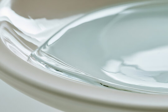 A close-up view of a serene glass bowl, emphasizing the intricate reflections and textures within, highlighting the delicate interplay of light and water that captivates.