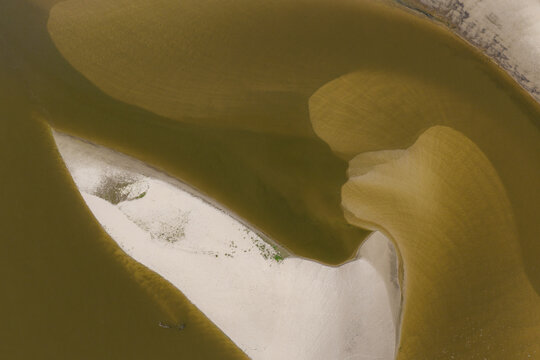 Aerial view of abstract river sandbars and sediment patterns forming organic shapes in the water in Poland.