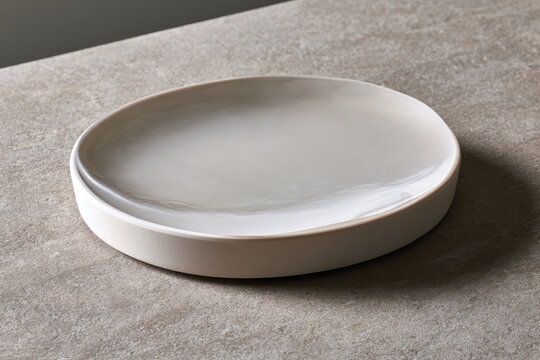 A soft-toned round plate with a stylish finish, perfect for enhancing any dining table setting, combining functionality with modern aesthetics in its elegant design.