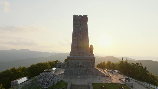 Shipka Monument sunset aerial view Bulgaria drone footage Balkan Mountains Pass Freedom Memorial stone tower historical landmark travel tourism destination peak landscape