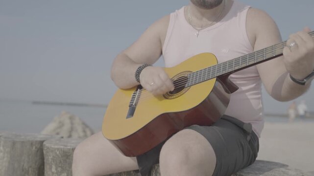 The boy is playing the guitar.