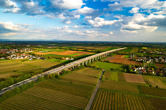 Aerial view of the highway bridge spanning across agricultural fields and rural landscapes near Edingen-Neckarhausen in Mannheim, Baden-Wurttemberg, Germany.