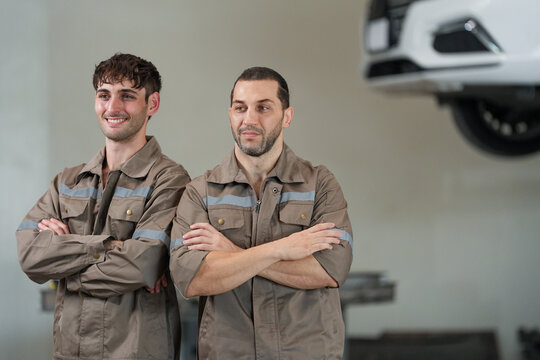 Mechanic car garage uniform worker repair automobile service two smiling man with crossed arm in auto workshop