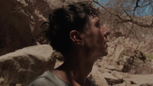 Sweaty man enduring extreme desert heat in arid mountain landscape highlighting hot climate resilience dehydration risk and environmental challenges under intense summer sun