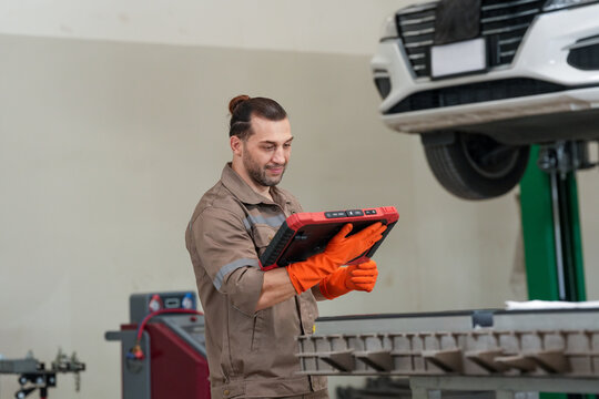 Car mechanic tablet garage vehicle repair diagnostic glove technician using tablet for vehicle repair diagnostic garage workshop, orange glove