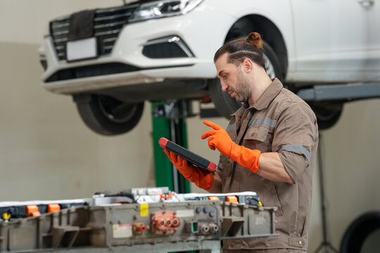 Car mechanic tablet glove garage vehicle lift repair male mechanic using tablet near raised car in auto service garage