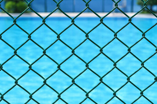 Green Chain Link Fence in Front of Blue Swimming Pool for Safety and Restricted Access