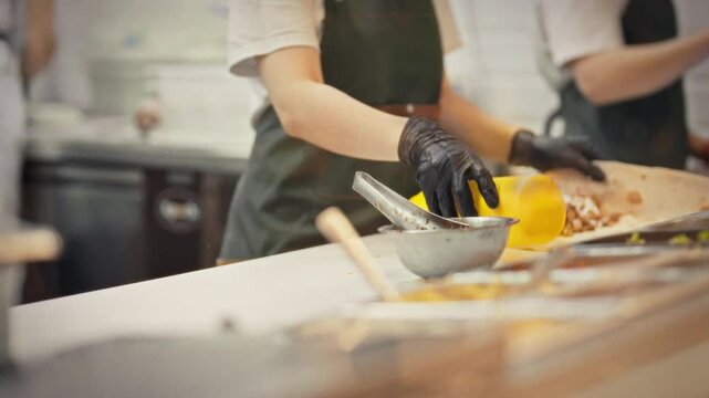 A chef wearing an apron and gloves adds white sauce to the meat and vegetable filling before wrapping the shawarma in lavash. The concept is fresh shawarma for takeaway