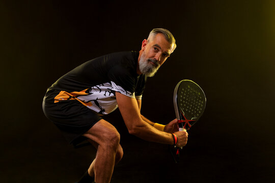 Padel tennis player with racket. Man athlete with paddle racket on court with neon colors. Sport concept.