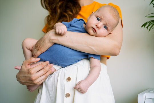 Mother holding her newborn baby boy, nurturing a loving bond through close physical contact, emphasizing maternal care and the precious early stages of parenthood, family connection concept