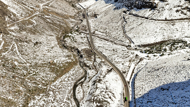 Aerial view of the winding road through the snow-covered Andes mountains with a river flowing alongside, Portillo, Valparaiso, Chile.