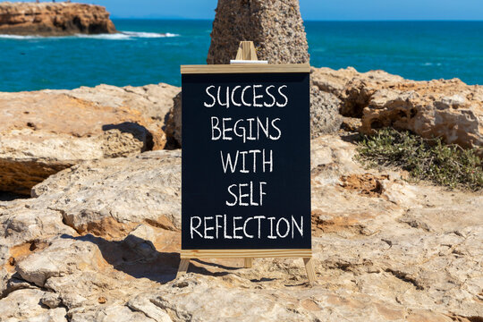 Self reflection symbol. Concept words Success begins with self reflection on beautiful black blackboard. Beautiful stone background. Business success begins with self reflection concept. Copy space.