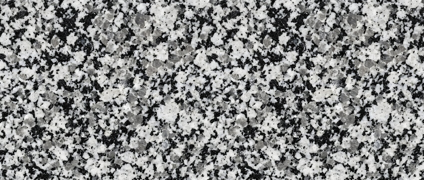 Granite rock texture featuring a dense aggregate of black biotite clusters and white crystalline feldspar fragments creates a solid natural abstract backdrop for architectural designs