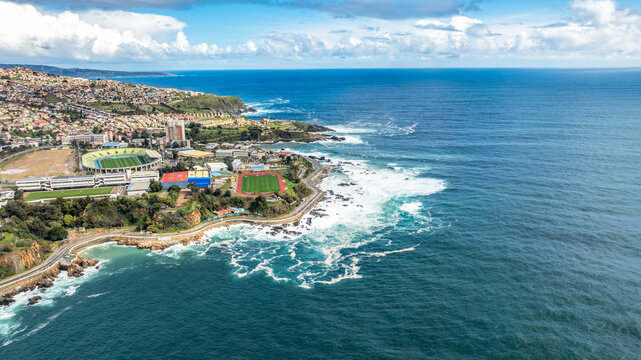 Aerial view of the coastline of Vina del Mar, featuring the Pacific Ocean, rocky shores, coastal roads, and sports stadiums in Vina del Mar, Valparaiso, Chile.