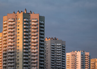 Iconic star-shaped residential skyscrapers Gwiazdy at Osiedle Walentego Rozdzienskiego in Katowice Poland illuminated by warm sunset light © kam8l