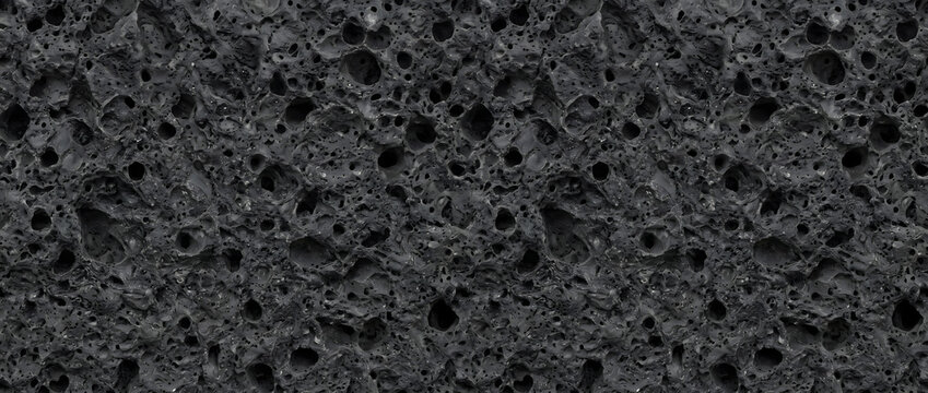 Pumice stone surface featuring a dark black volcanic lava texture with detailed porous holes delivers an impactful organic abstract background for modern creative designs