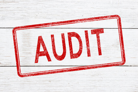 Red distressed Audit stamp on weathered wood for financial review