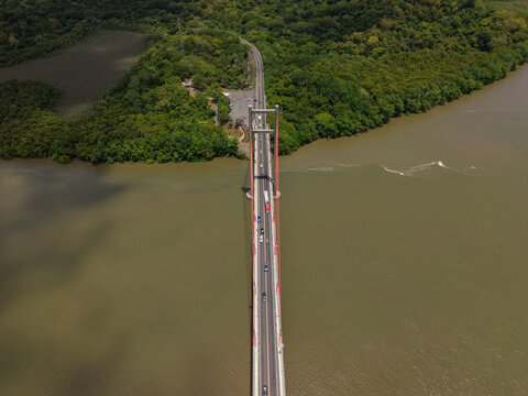 Aerial view of Puente La Amistad spanning the Tempisque River, surrounded by lush tropical forest and riverbanks in Bagaces, Guanacaste Province, Costa Rica.