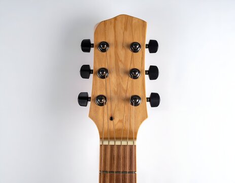 Headstock of an acoustic guitar with light wooden neck and black tuning pegs