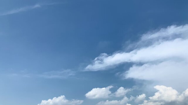 Expansive blue sky with soft cloud formations, minimalist atmospheric background texture designed for environmental, seasonal, promotional, and creative video compositions.