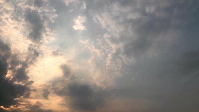 Dramatic sunset sky with glowing sunlight behind dense clouds, cinematic atmospheric background texture ideal for nature, weather, emotional storytelling, and scenic productions.