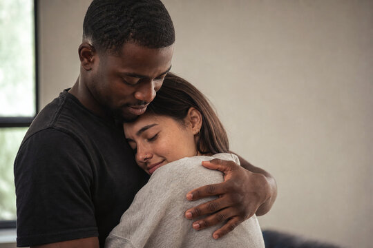 Tender embrace between diverse couple with warm comfort