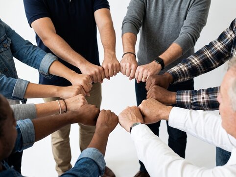 Team of diverse hands stacked together in unity gesture