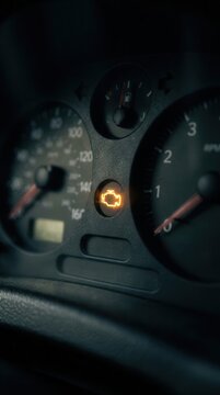 Illuminated Car Engine Warning Light Glowing on the Dashboard Instrument Panel, Signaling Potential Mechanical Issues and the Need for Professional Vehicle Maintenance and Diagnostics