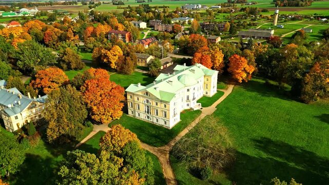 Riga, Latvia - 06 November 2024: Aerial view of a historic manor house surrounded by vibrant autumn trees and green lawns.