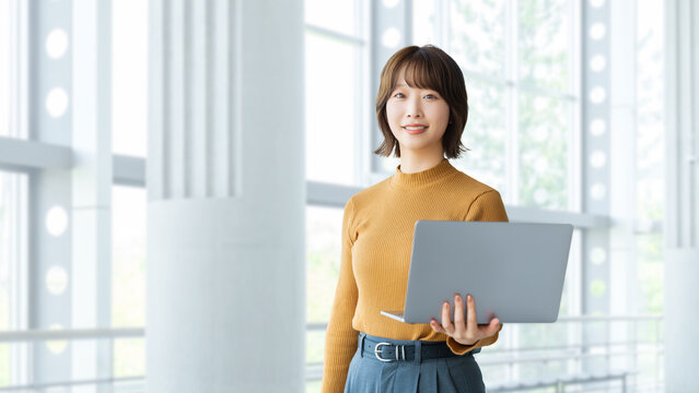 ノートパソコンを持つ女性・ビジネスウーマン, Businesswoman Holding a Laptop Computer