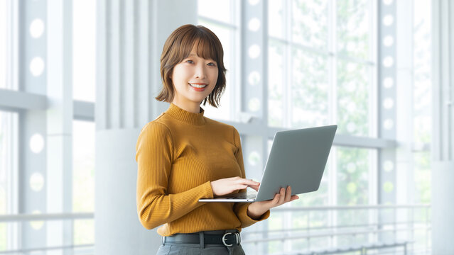 ノートパソコンを持つ女性・ビジネスウーマン, Businesswoman Holding a Laptop Computer