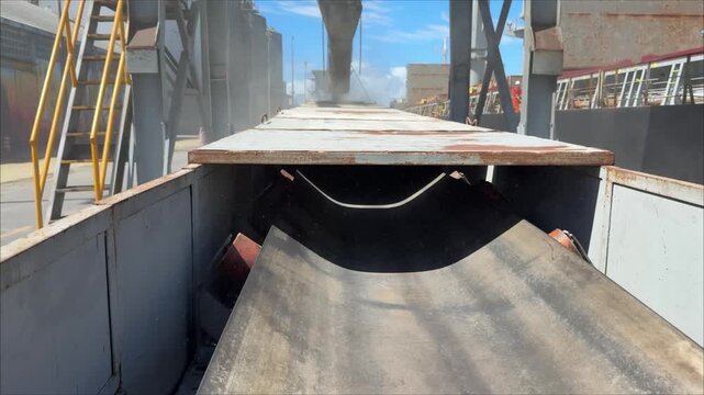 conveyor belt for grain transportation working. grain with dust leaking from hopper.