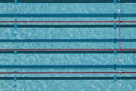 The Aerial View of a Striped Swimming Pool with Turquoise Tiles