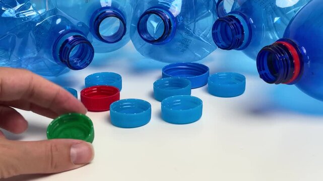 Woman's hand sorting colorful plastic bottle caps for recycling and environmental concept