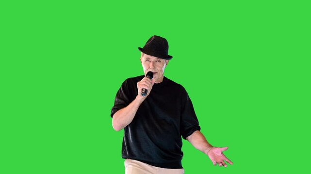 Experienced musician expressively sings a song into the mic on a Green Screen, Chroma Key.