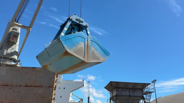 grab of crane discharging malt in bulk from the ship
