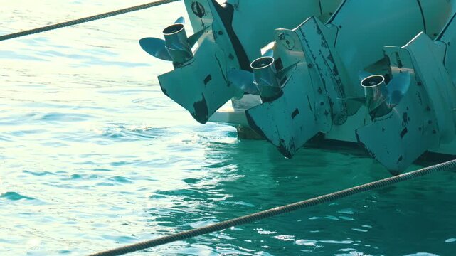 White Boat Motors Tilted Above Blue Ocean